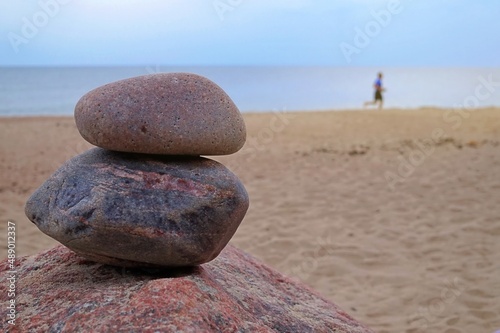 Two stacked natural rocks on a sandy beach