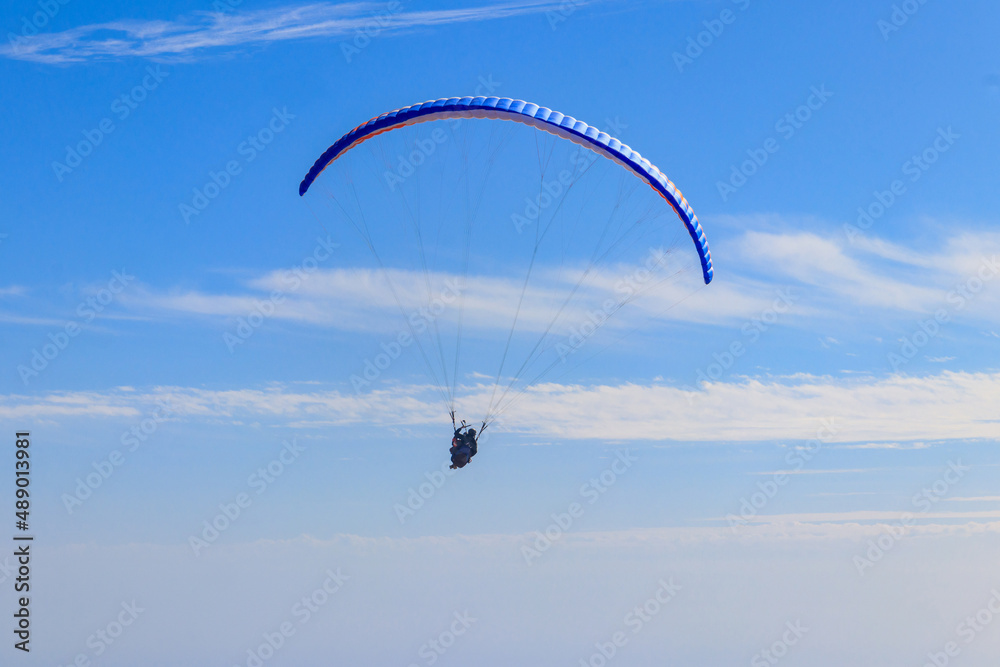 Paragliders in blue sky. Concept of active lifestyle and extreme sport adventure Paragliders in blue sky. Concept of active lifestyle and extreme sport adventure