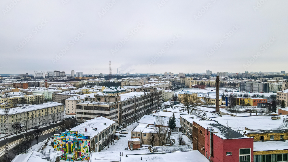 Beautiful top view of cityscape with tv tower, ferris wheels, factory and buildings in winter.