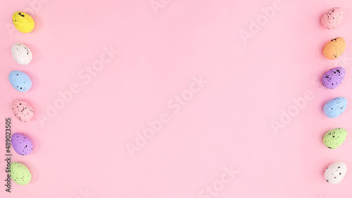 Easter bright pink background with colorful eggs on left and right side. Copy space creative composition. © Long Frame