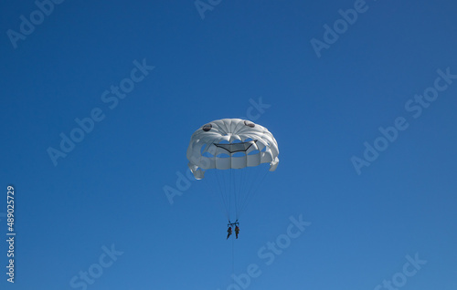 White parachute in blue sky , parasailing, paragliding.