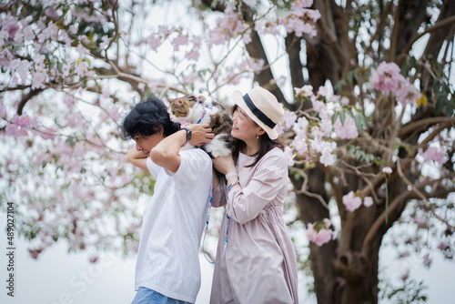 asian couple travel outdoor with cat with pink flower in springtime season