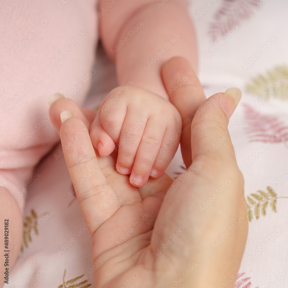 Petite main de bébé nouveau né dans la main de sa maman. Amour