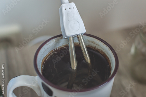 Instant Immersion Heater Electric Water Portable Reheater warms up or boils coffee in a mug. Close-up