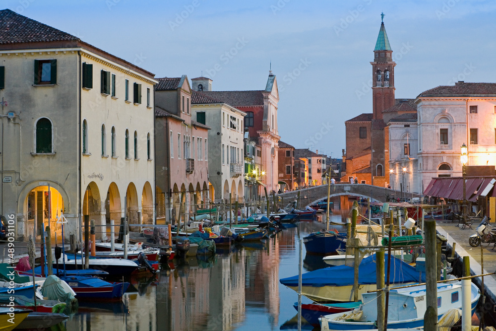Chioggia, Venezia. Canal Vena al tramonto con barche da pesca, Palazzi, ponte e campanile della Chiesa Parrocchiale di San Giacomo Apostolo
