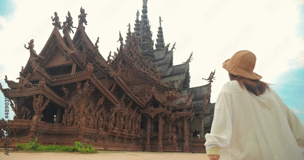 Sanctuary of Truth (Prasat Sut Ja-Tum), Rear view of woman 
tourist at beautiful Thai wooden temple interior in Pattaya Thailand, Amazing Thailand travel concept.