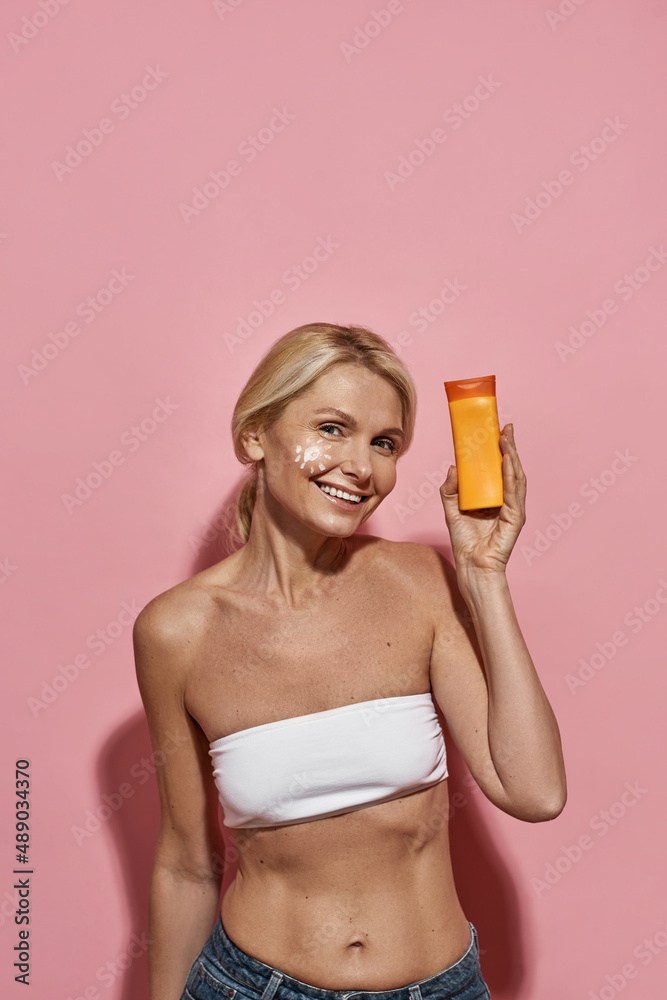 Smiling mature caucasian woman with sun cream Smiling mature caucasian woman with sun cream