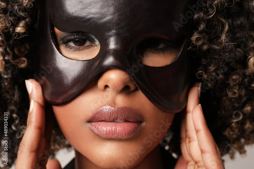 Portrait of black young woman with leather black mask on her face. Close-up.