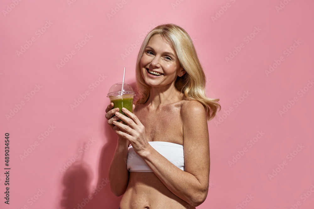 Pleased woman drinking cocktail from plastic cup Pleased woman drinking cocktail from plastic cup