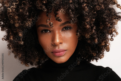 African American beauty. Young woman with curly hair on white background.