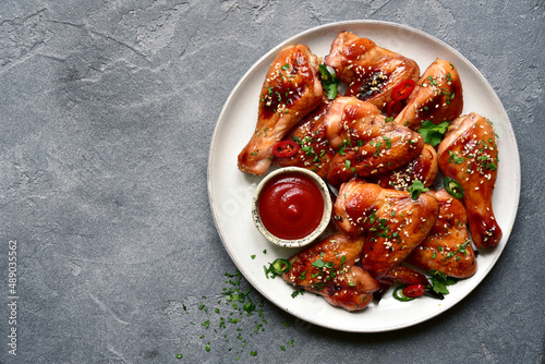 Grilled spicy chicken legs and wings with ketchup. Top view with copy space.