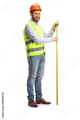 Full length shot of a smiling male engineer using a steel tape measure