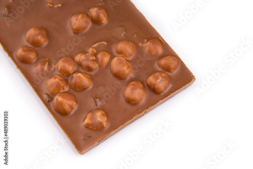 Macro photo of Chocolate bar. Broken pieces over white background. Pieces of milk chocolate with nuts isolated on white background