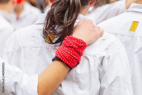 Non-recognizable people with their hand on the back of another preparing to make Castellers or Torre Humana, a typical tradition in the festivities of Catalon photo