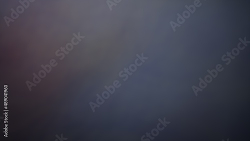 Blurred abstract background of green, white, black, red, orange and purple.