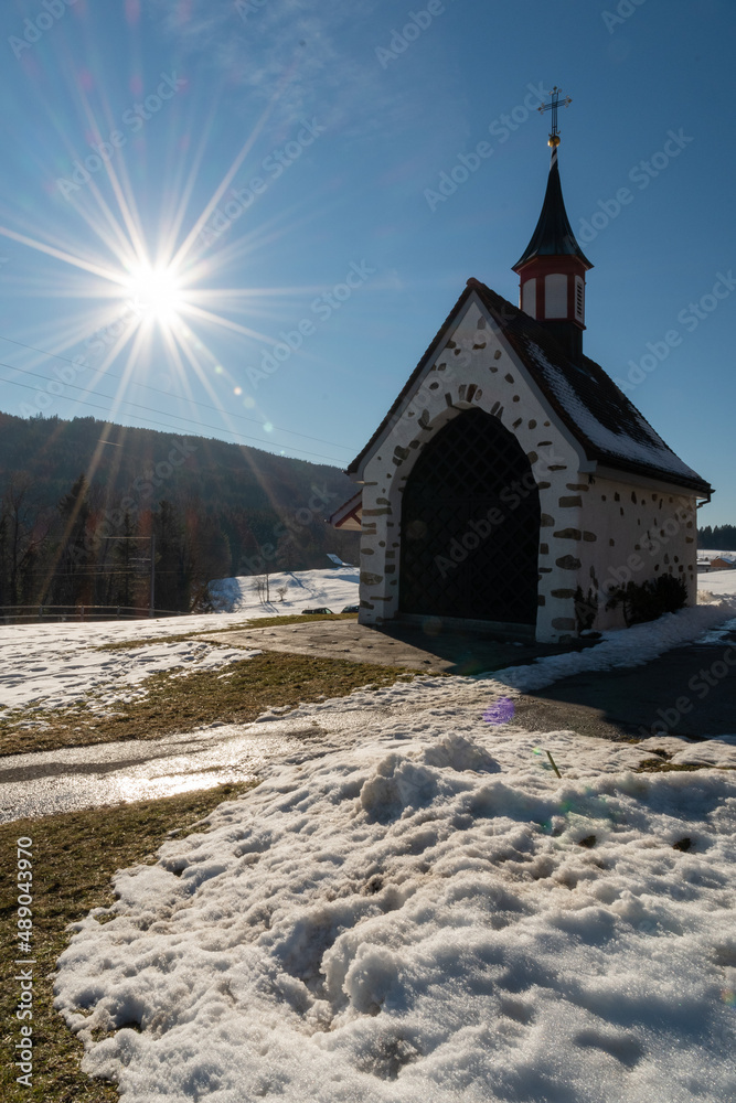 Sun rays behind a little chapel in Gais in Switzerland
