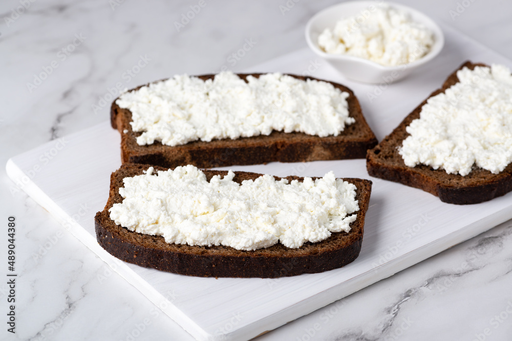 Rye bread with cottage cheese on a white table