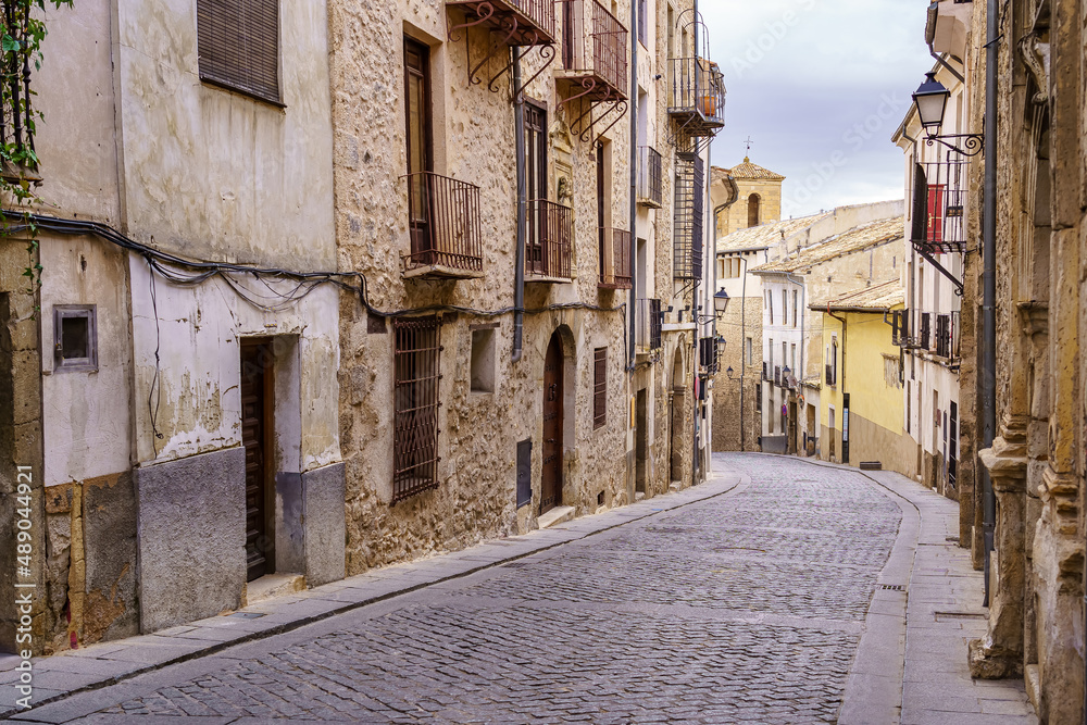 Narrow cobblestone floor street and medieval doors in the city of Cuenca, Spain.