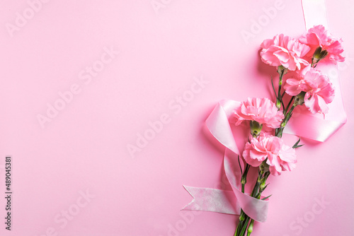Pink carnation flowers and ribbon © mizina