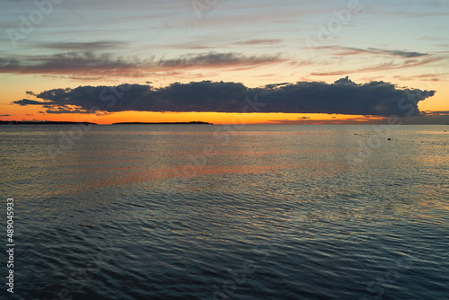 Obraz na płótnie Long big dark cloud over the sea at sunset w salonie
