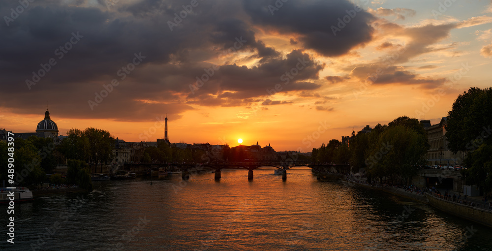 Paris summer view on the Seine River Banks (UNESCO World Heritage Site) with the Pont des Art and Eiffel Tower at Sunset. 1st and 6th Arrondissements. France