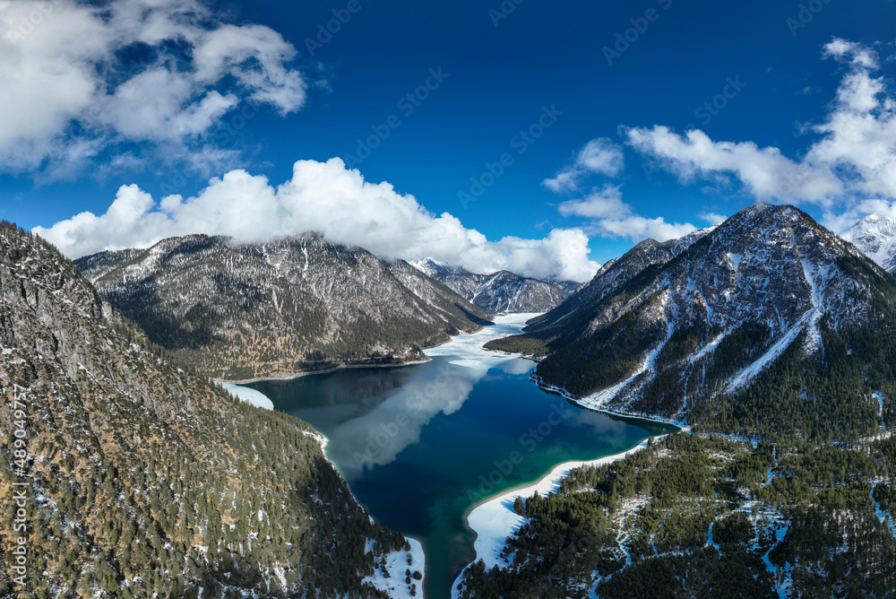 cold blue lake plansee on sunny day in tyrol alps mountains in winter