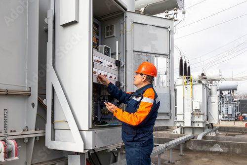 An engineer working at a substation. power distribution switchgear equipment condition check