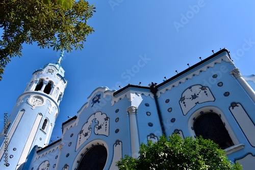 Blue Church in Bratislava, Slovakia immersed with two beautiful green trees highlighting it in the middle of the picture frame