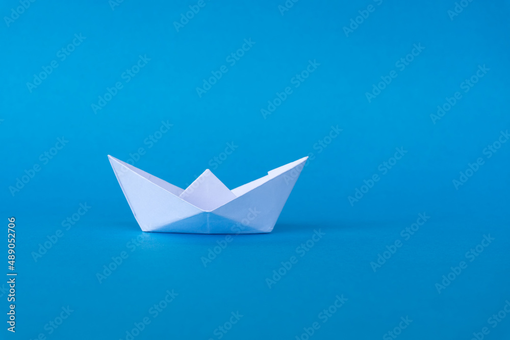 Business concept - paper ship origami on blue background. Business concept - paper ship origami on blue background.