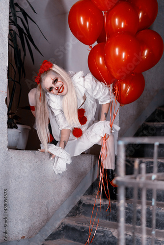 clown pennywise in an old building with red balloons