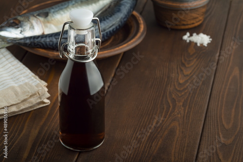 prepared by fermentaion of fish salty sauce garum in a bottle on brown wooden background