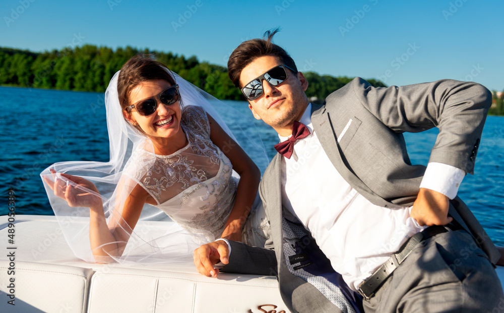 Newlywed. Young couple. Groom and bride. Photo session on a speedboat. Lake