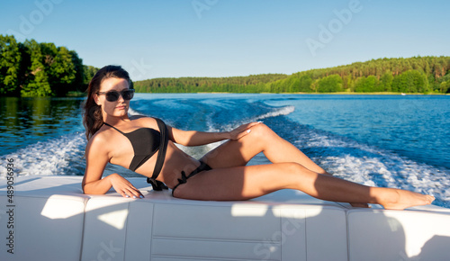 Beautiful brunette in a bikini on a speedboat