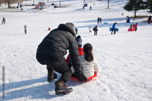 Fototapeta Winter sport toboggan -  father and daughter playing toboggan, winter, outside, healthy lifestyle