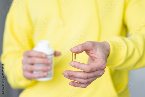Male hand holding a pill. Closeup. Healthcare and medicine concept.