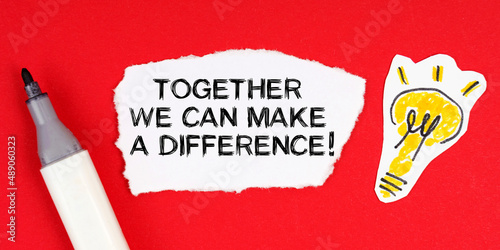 On the red surface are a marker, light bulbs and paper with the inscription - Together We Can Make A Difference photo