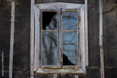 Sunja, Croatia, 05,04,2021: Rustic style aged window in wooden village rural home wall.