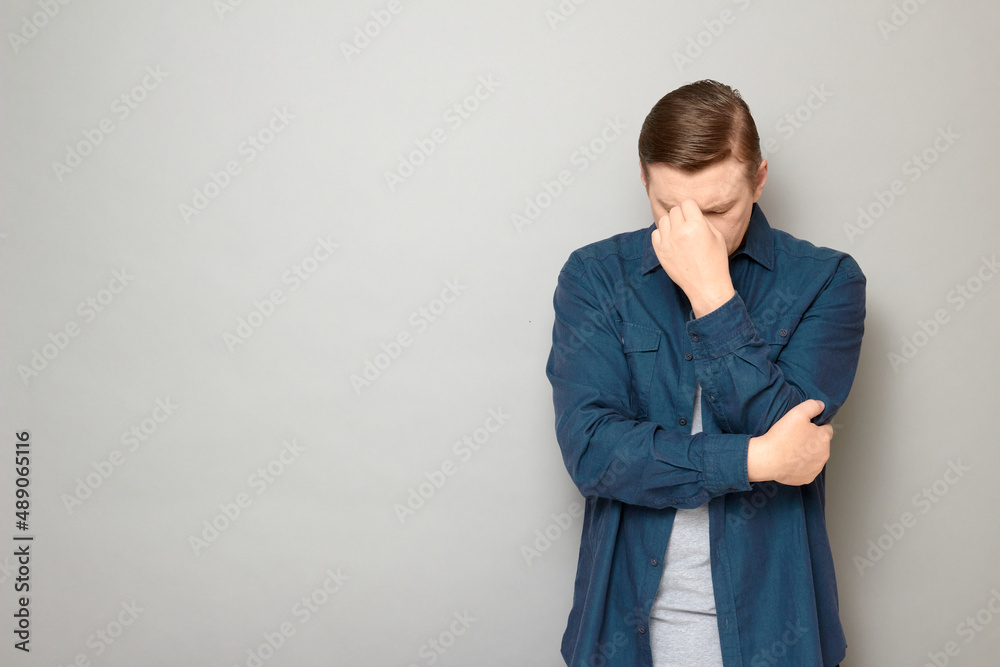 Shot of mature man keeping head down and touching bridge of his nose Shot of mature man keeping head down and touching bridge of his nose