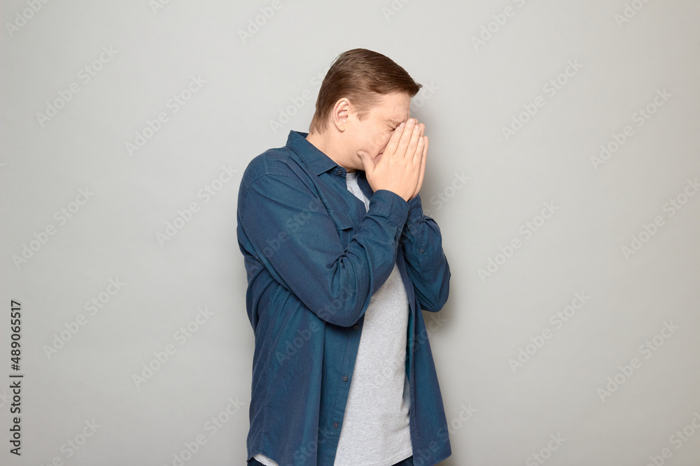 Portrait of unhappy mature man covering face with hands Portrait of unhappy mature man covering face with hands