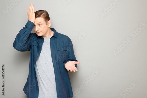 Portrait of disappointed confused man slapping his forehead with hand