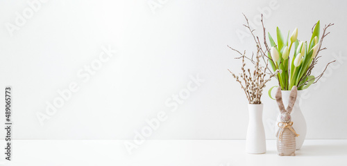 White spring tulips in a vase, easter bunny on a white table. Mock up for displaying works