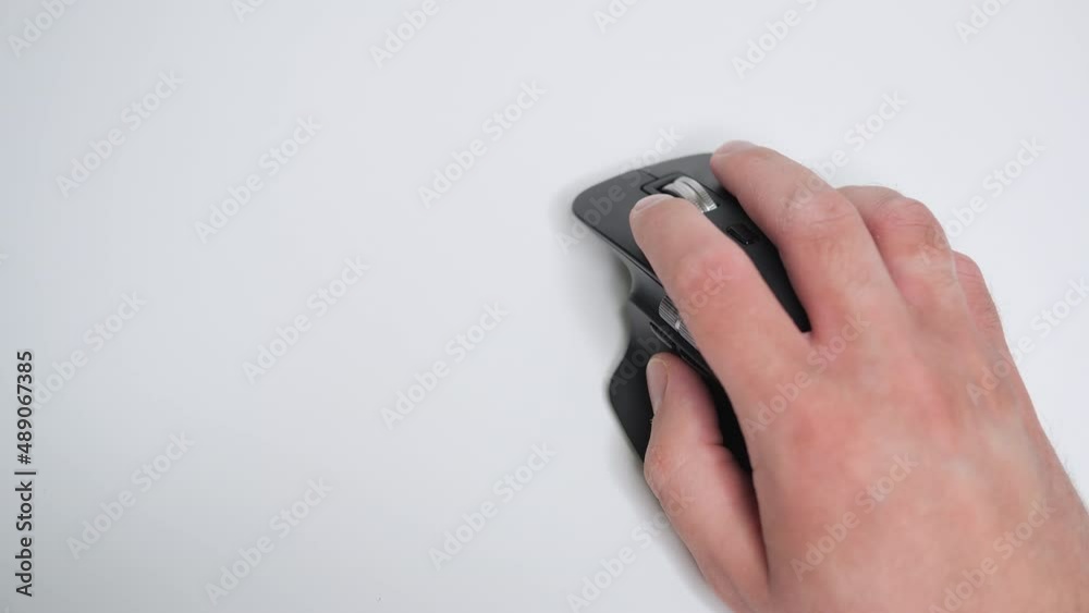 Top view on the man's hand using modern wireless laser mouse. Man using computer mouse on white background. Space for text Top view on the man's hand using modern wireless laser mouse. Man using computer mouse on white background. Space for text