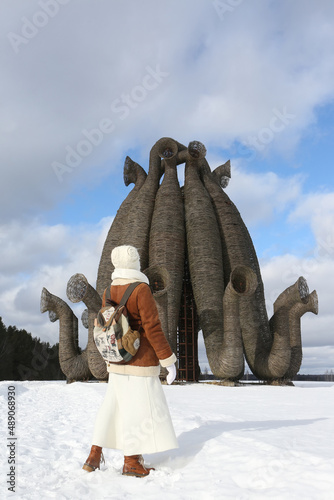 Russian tourist woman, girl with backpack. Nikola-Lenivets park, Kaluga region, Russia. Wooden architecture, landmark, monument. Bobur by Nikolai Polissky photo