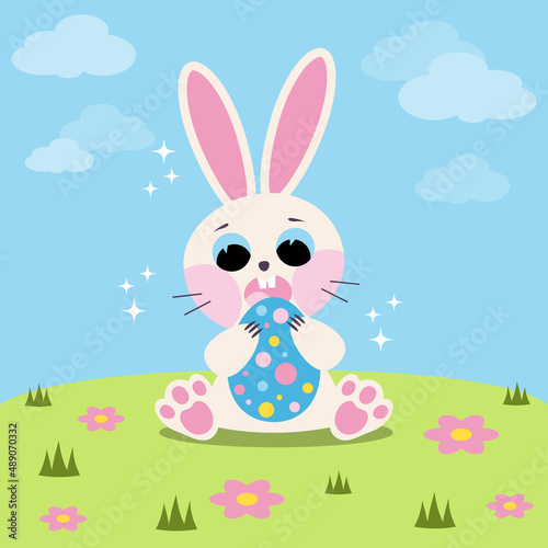 A white rabbit in a flower meadow. Easter bunny with egg.