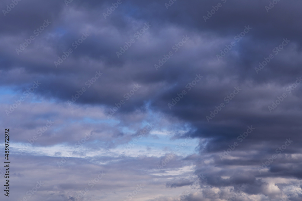 Epic Dramatic storm dark grey cumulus rain clouds against blue sky background texture, thunderstorm	
