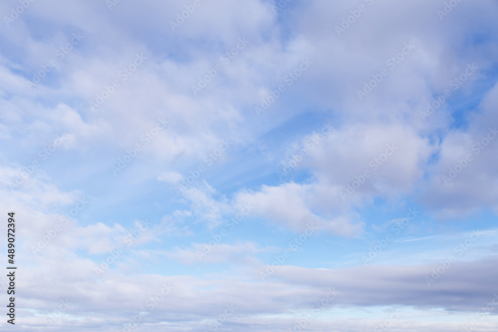 Beautiful epic soft gentle blue sky with white and grey cirrus and fluffy clouds background texture