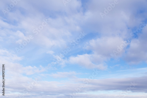 Beautiful epic soft gentle blue sky with white and grey cirrus and fluffy clouds background texture