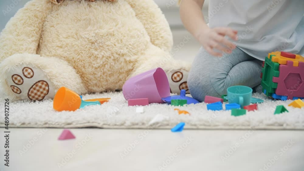 4k slowmotion close up video of little girl playing with teddy bear sitting on the floor. 4k slowmotion close up video of little girl playing with teddy bear sitting on the floor.