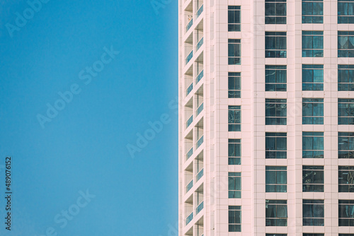 Wall With A Balcony Of New Empty Modern Multi-storey Residential Building House In Residential Area On Sunny Blue Sky. © Grigory Bruev