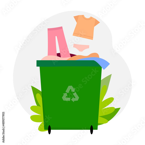 Green container with old clothes for voluntary donations or clothing recycling